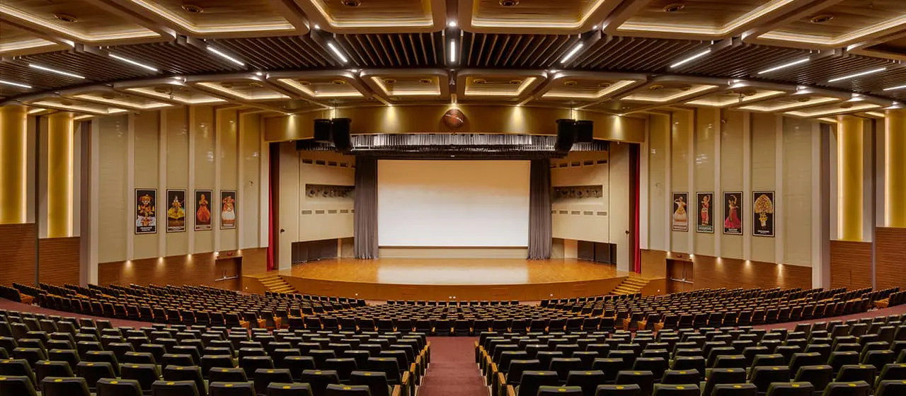 An auditorium with rows of chairs and a stage featured in the Guide to Auditorium Lighting - The Ultimate Guide to Auditorium Lighting - Vorlane - Vorlane